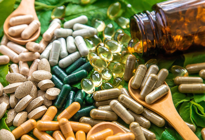 Vitamin K-reiche Lebensmittel auf einer schwarzen Tischplatte. In der Mitte liegt eine Tafel mit der Aufschrift 