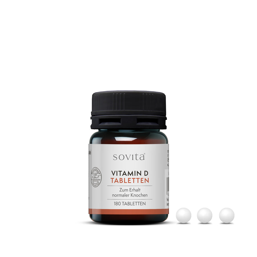 sovita Vitamin D Tabletten mit geöffneter Dose und drei weißen Tabletten im Vordergrund